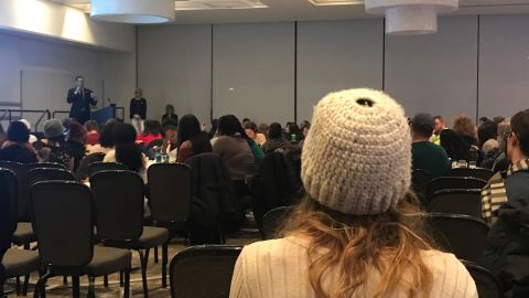 Nassar survivor Kat Ebert, in white, listens as MSU trustee Mosallam speaks at a Thursday town hall on campus.
