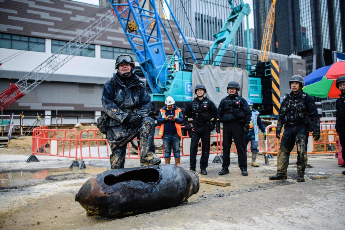 Bomb disposal expert Adam Roberts, left, rests his foot on a defused US-made bomb dropped during World War II a day after it was discovered on a harborfront construction site in the Wan Chai district of Hong Kong on February 1. 