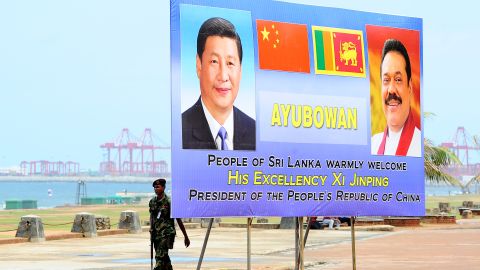 A Sri Lankan soldier walks past a billboard bearing portraits of Chinese President Xi Jinping and Sri Lankan President Mahinda Rajapakse, ahead's of Xi's visit to the Sri Lankan capital Colombo, on September 15, 2014. 