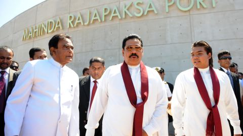 Sri Lanka's President Mahinda Rajapakse, center, flanked by his eldest son and parliamentarian Namal Rajapakse, right, and Prime Minister D. M. Jayaratne, left, tour the Hambantota construction site, November 18, 2010. 