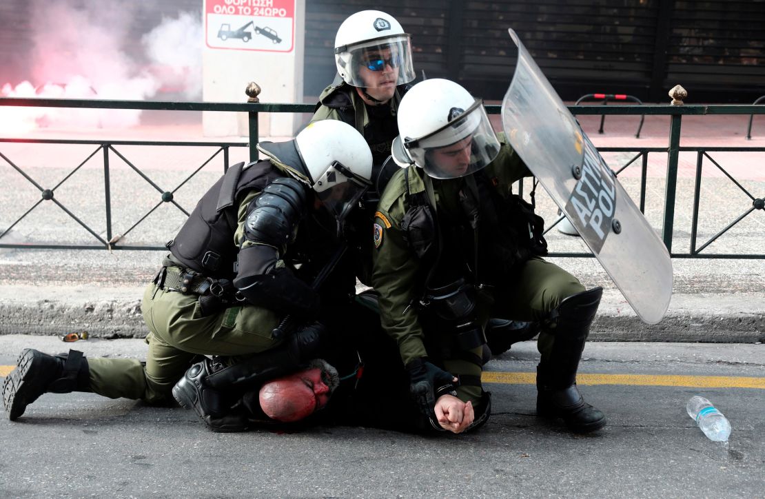 Riot policemen detain a protester during a scuffle on the sidelines of a rally in Athens, Sunday, February 4, 2018.