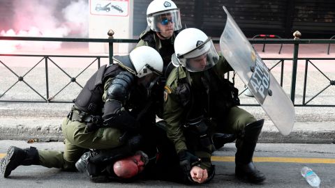 Riot policemen detain a protester during a scuffle on the sidelines of a rally in Athens, Sunday, February 4, 2018.