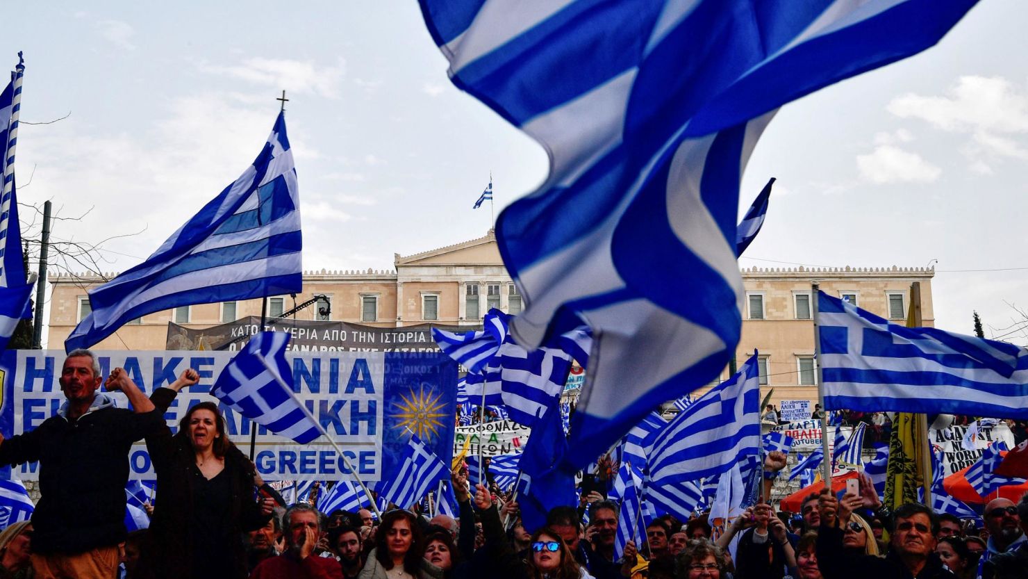Protesters in Athens wave Greek flags as they  urge the government not to compromise over the name of neighboring Macedonia.