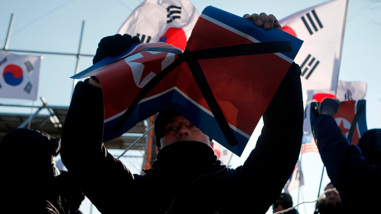 INCHEON, SOUTH KOREA - FEBRUARY 04: A South Korean tear the National flag of North Korea at the anti-North Korean rally before the Women's Ice Hockey friendly match at Seonhak International Ice Rink on February 4, 2018 in Incheon, South Korea. The friendly match is held ahead of the Olympic Games where South and North Korea competes for the first time as a unified team in a sport at the Olympic Games.  (Photo by Woohae Cho/Getty Images)