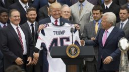 US President Donald Trump holds a jersey given to him by New England Patriots owner Robert Kraft (R) and head coach Bill Belichick (L) alongside members of the team during a ceremony honoring them as 2017 Super Bowl Champions on the South Lawn of the White House in Washington, DC, April 19, 2017.