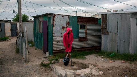 A woman collects water in a settlement near Cape Town on Friday, February 2.