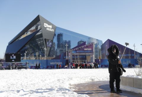 A fan takes a selfie outside US Bank Stadium before the game. The game is indoors, but outside it is the coldest Super Bowl on record.