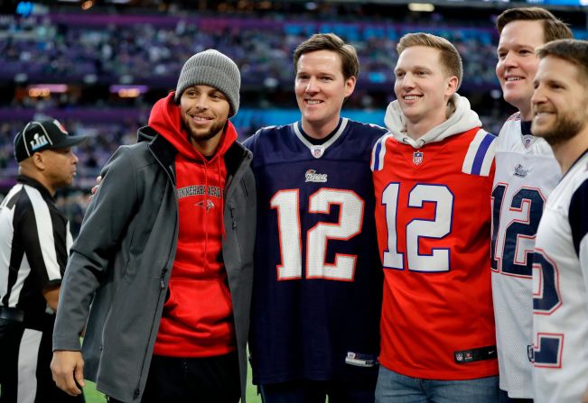 Basketball star Stephen Curry, left, poses for a photo with Patriots fans.
