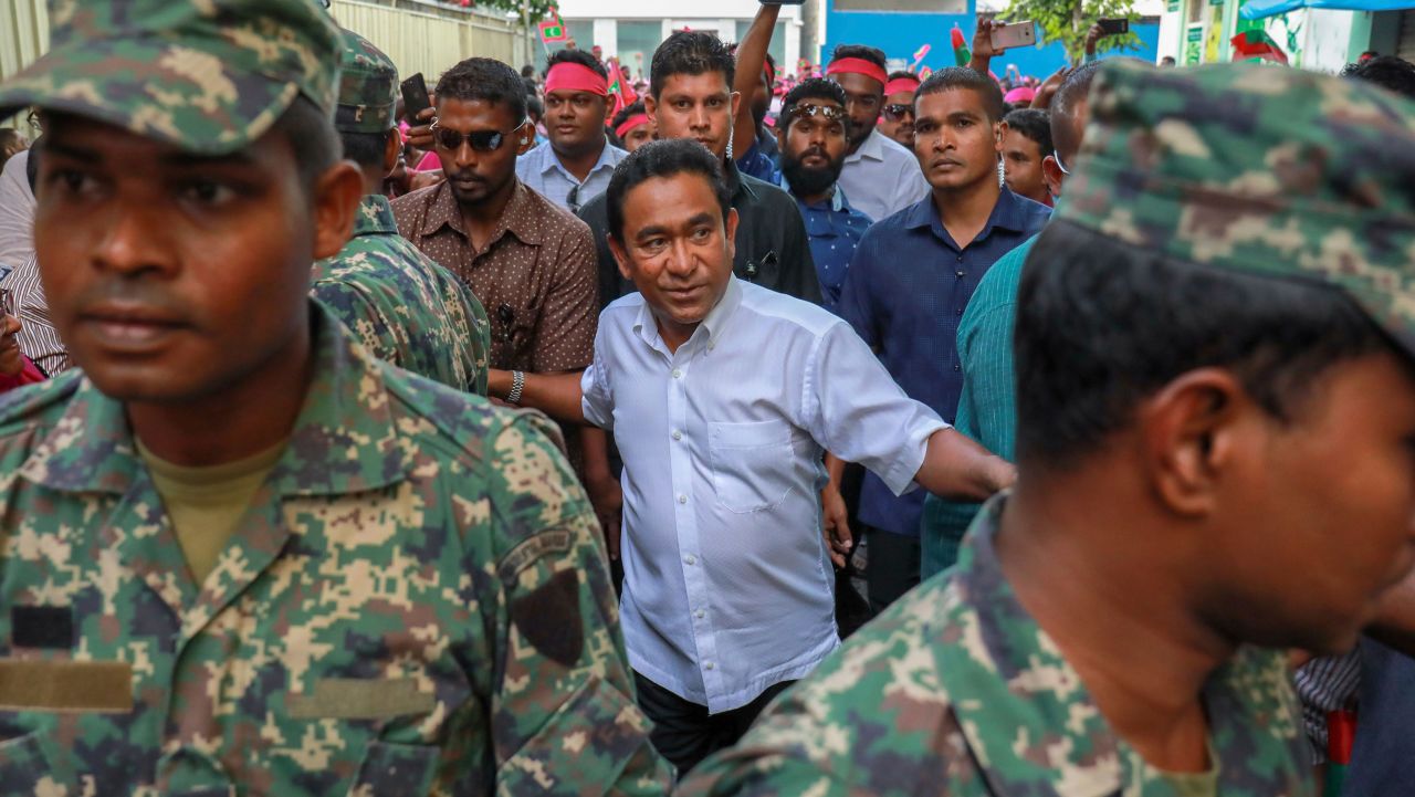 Maldivian president Yameen Abdul Gayoom, center, surrounded by his body guards arrives to address his supporters in Male, Maldives, Saturday, Feb. 3, 2018. President Yameen said Saturday that he was willing to hold an early presidential election to allow voters to decide who they want to lead the Indian Ocean archipelago, as political unrest continued to grow after a court ordered the release and retrial of political prisoners.(AP Photo/Mohamed Sharuhaan)