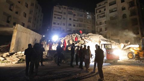 Rescuers search for members of four families reportedly stuck under the rubble of a six-story building that collapsed following regime  airstrikes on Idlib on Sunday.