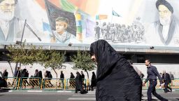 An Iranian woman walks past pictures of Iranian supreme leader Ayatollah Ali Khamenei (top L) and of late Iranian supreme leader Ayatollah Ruhollah Khomeini (top R), following the weekly Friday prayer in Tehran on October 13, 2017.President Donald Trump will unveil a more aggressive strategy to check Iran's growing power, but will stop short of withdrawing from a landmark nuclear deal or declaring the powerful Islamic Revolutionary Guard Corps a terrorist organization. During a White House speech at 12:45 pm (1645 GMT), Trump is expected to declare the 2015 agreement -- which curbed Iran's nuclear program in return for sanctions relief -- is no longer in the US national interest. / AFP PHOTO / STR        (Photo credit should read STR/AFP/Getty Images)