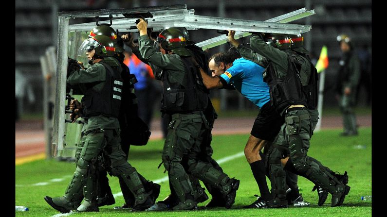 Soccer referee Daniel Fedorczuk is escorted off the field by members of the national guard after a Copa Libertadores match in San Cristobal, Venezuela, on Thursday, February 1. Some fans of the Venezuelan club Deportivo Tachira threw objects onto the field after a 3-2 loss to Colombian club Santa Fe.
