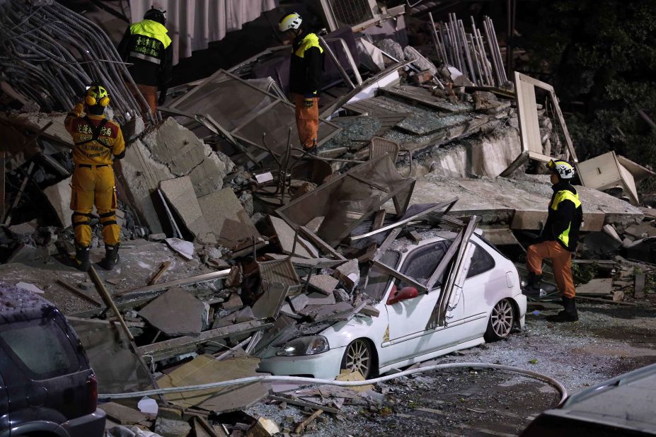 Members of the emergency services search for people in the debris of a collapsed building.
