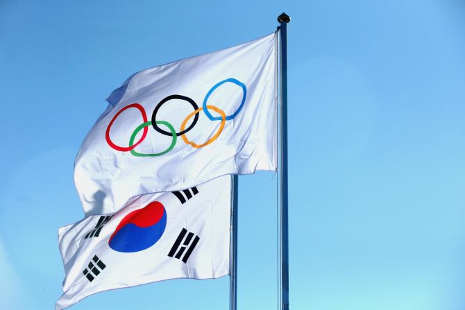 The national flag of South Korea with the Olympic flag at the Pyeongchang 2018 Olympic Village. The Olympic flag was designed by Pierre de Coubertin, founder of the International Olympic Committee, in 1913, but it only officially debuted at the Summer Games of 1920 in Antwerp, Belgium. The rings represent the world's five inhabited continents, but their colors were chosen by Coubertin because all of the world's flags at the time could be made from them (including the white of the background.) 