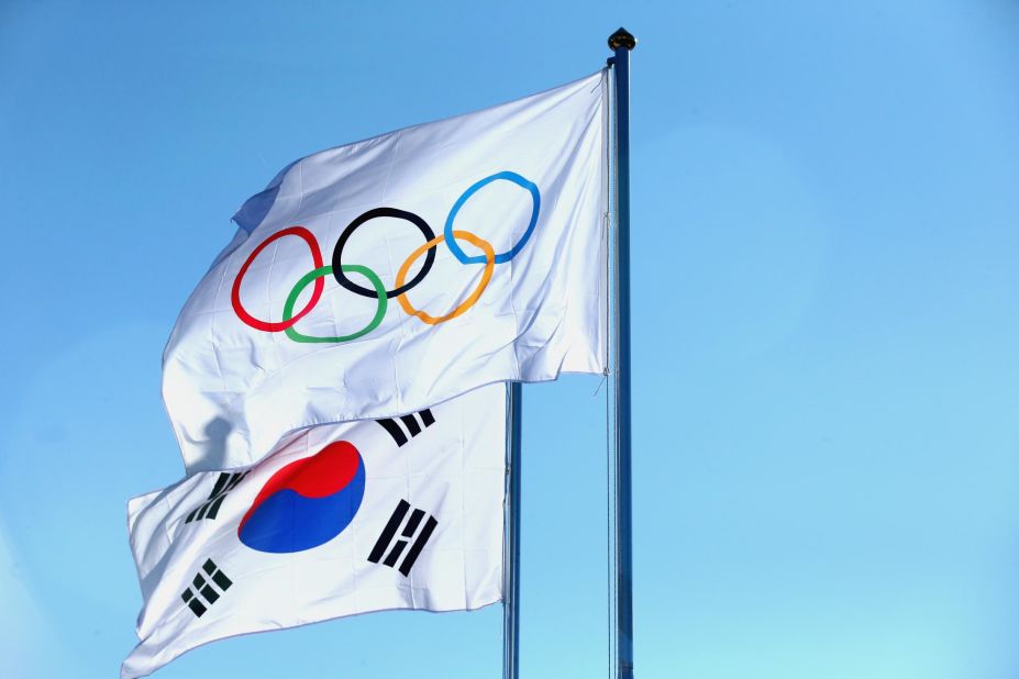 The national flag of South Korea with the Olympic flag at the Pyeongchang 2018 Olympic Village. The Olympic flag was designed by Pierre de Coubertin, founder of the International Olympic Committee, in 1913, but it only officially debuted at the Summer Games of 1920 in Antwerp, Belgium. The rings represent the world's five inhabited continents, but their colors were chosen by Coubertin because all of the world's flags at the time could be made from them (including the white of the background.) 