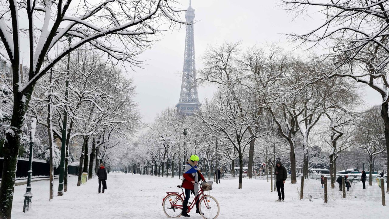 People walk through the snow covered alley of the Champ de Mars following heavy snowfall in Paris, on February 7, 2018 near the Eiffel tower.
Exceptionally heavy snowfall brought public transport in Paris and surrounding regions to a near halt on February 7, spelling misery for commuters after hundreds were forced to abandon their cars to sleep in emergency shelters overnight.  / AFP PHOTO / Thomas SAMSON        (Photo credit should read THOMAS SAMSON/AFP/Getty Images)