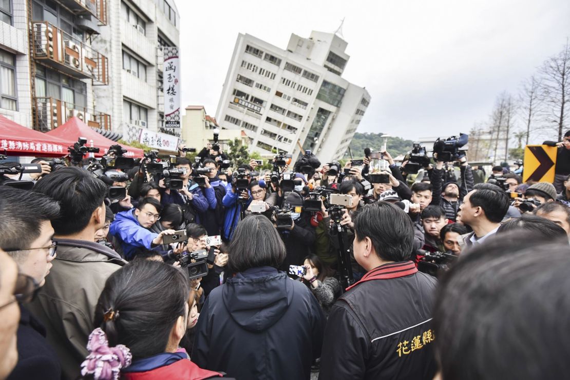 Taiwanese President Tsai Ing-wen, center, is briefed at the site of a collapsed building Wednesday.