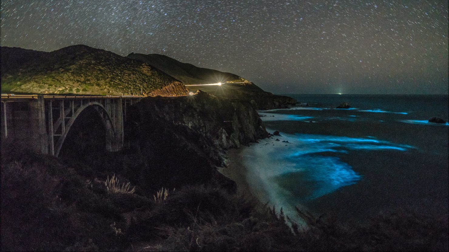 Phytoplankton concentrations in the waters below Bixby Creek Bridge illuminate the darkened waters. 