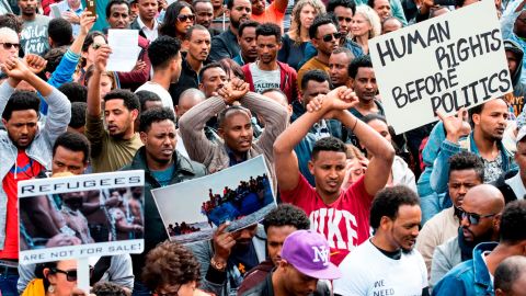 African migrants demonstrate with their hands crossed outside the Embassy of Rwanda in the Israeli city of Herzliya on February 7, 2018.