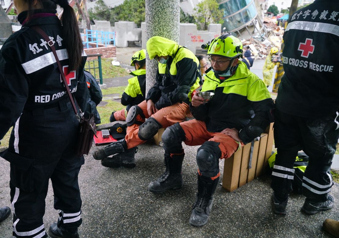 Rescuers rest near the site of damaged buildings in Hualien on February 8.