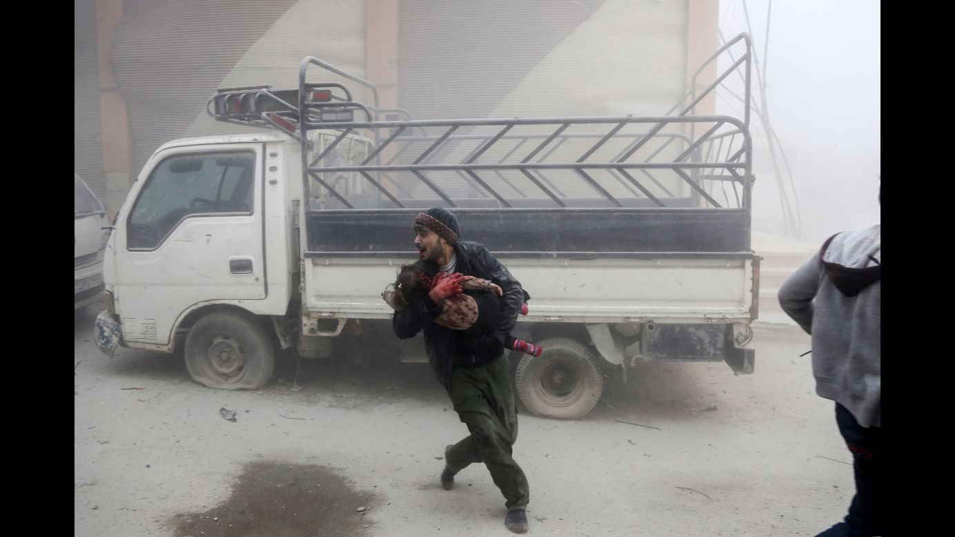 A man carries a child as he flees from a reported Syrian airstrike in the rebel-held town of Saqba, in the Eastern Ghouta region of Syria, on Tuesday, February 6. More than 200 civilians have been killed since Monday, February 5, in <a href="http://www.cnn.com/2018/02/08/middleeast/syria-eastern-ghouta-airstrikes/index.html" target="_blank">Syrian government airstrikes on parts of Eastern Ghouta</a> near Damascus, the Syrian Observatory for Human Rights said. Among the deaths were 54 children and 41 women.