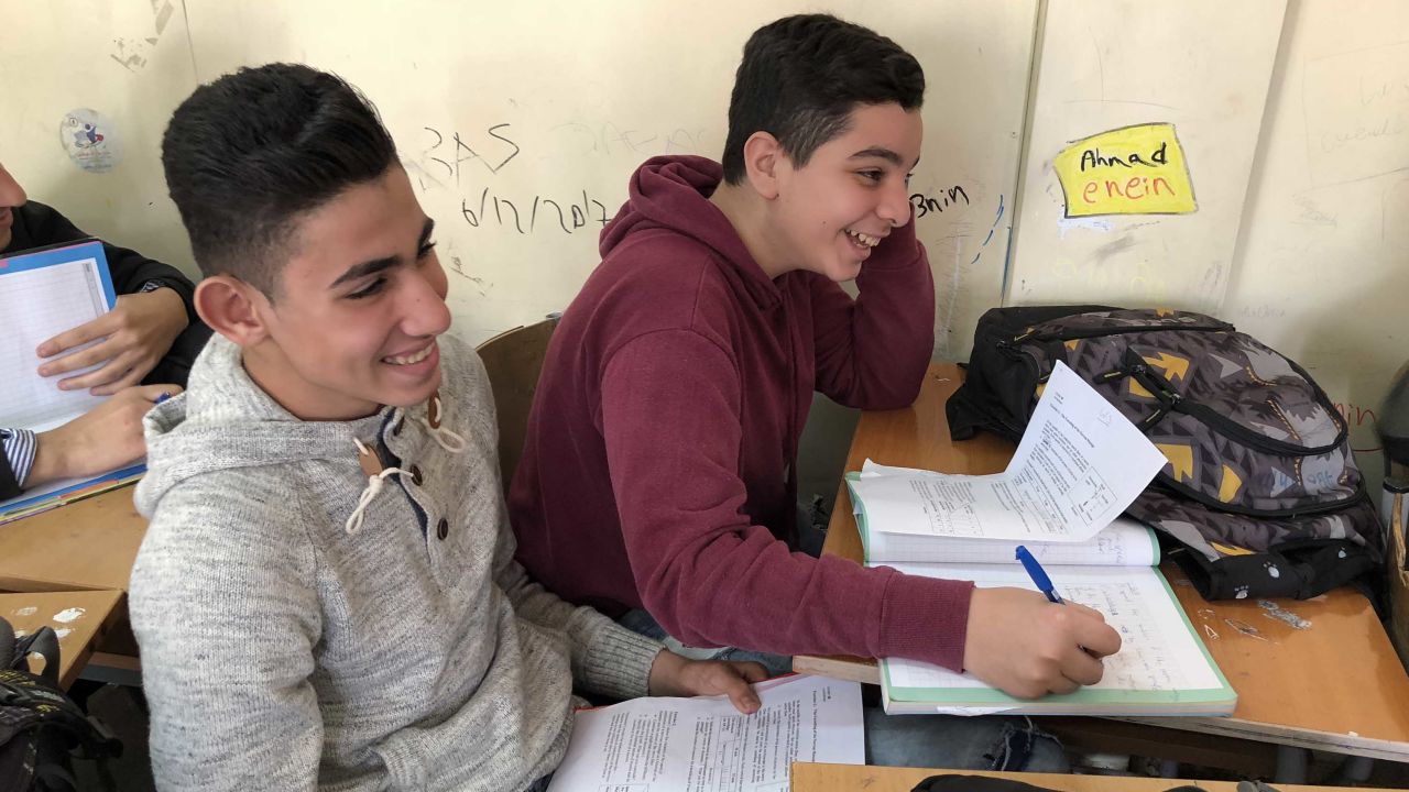 Some students share single desks with others so they can all fit into crammed classrooms.