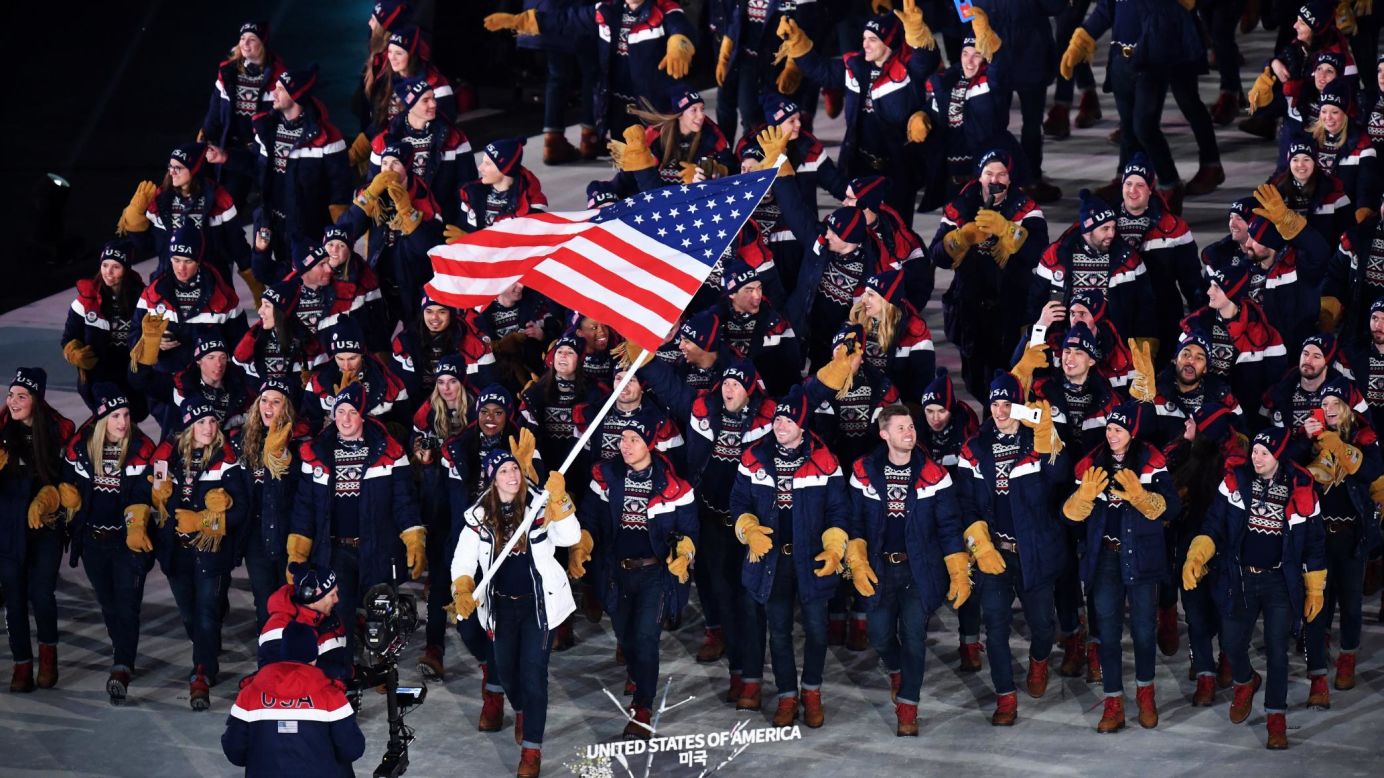 Luger Erin Hamlin carries the American flag as she leads US athletes during the Winter Olympics' opening ceremony on Friday, February 9. Hamlin is a four-time Olympian who won bronze in 2014.
