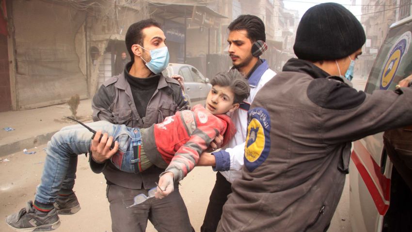 Members of Syrian Civil Defence carry an injured child following regime air strikes on the rebel-held besieged town of Douma in the eastern Ghouta region, on the outskirts of the capital Damascus, on February 7, 2018. / AFP PHOTO / Hamza Al-Ajweh (Photo credit should read HAMZA AL-AJWEH/AFP/Getty Images)