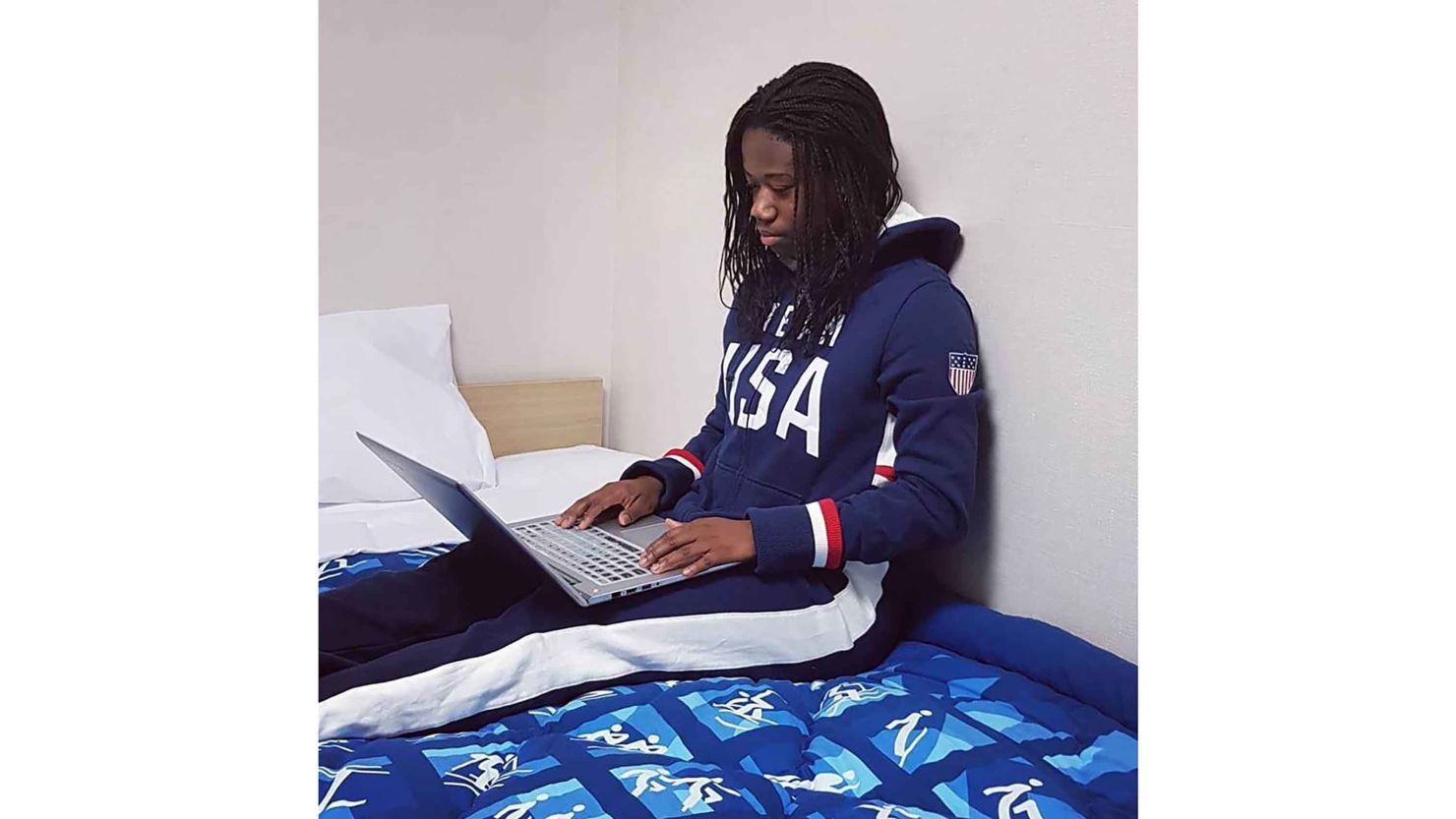 Long track speed skater Erin Jackson of Team USA watches the opening ceremony on her laptop.