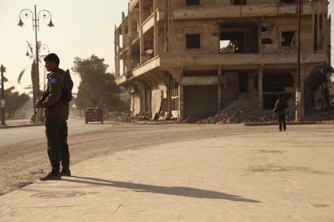 Members of the newly formed RISF or Raqqa Internal Security Force stand guard on a street.