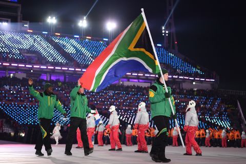 Flag bearer Connor Wilson of South Africa leads the team during the Opening Ceremony. The alpine skier is the sole representative for South Africa in the Winter Olympics. 