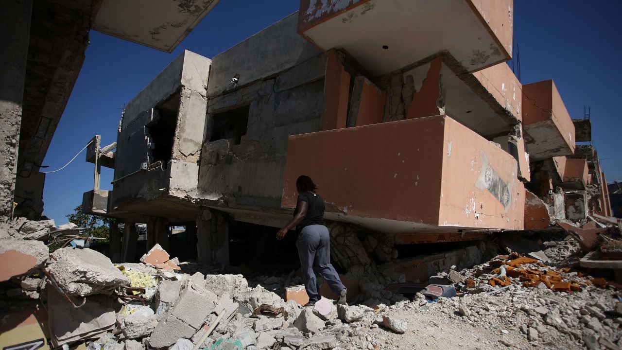 A woman walks before a destroyed building on January 5, 2011  in Port-au-Prince. One year after Haiti's earthquake, only five percent of the rubble has been cleared as crippling "indecision" has stalled reconstruction efforts, a new report by humanitarian group Oxfam said. "This has been a year of indecision and it has put Haiti's recovery on hold," said Roland Van Hauwermeiren, country director for Oxfam in Haiti.