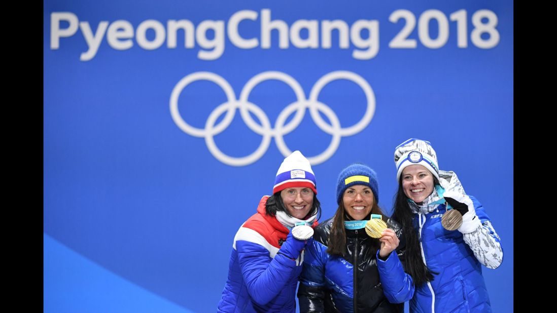 Sweden's Charlotte Kalla, center, celebrates after winning the first gold medal of the 2018 Winter Olympics. She finished first in the 15-kilometer cross-country ski event. Norway's Marit Bjørgen, left, won the silver to become the most decorated woman in the history of the Winter Games. Finland's Krista Parmakoski took the bronze. 