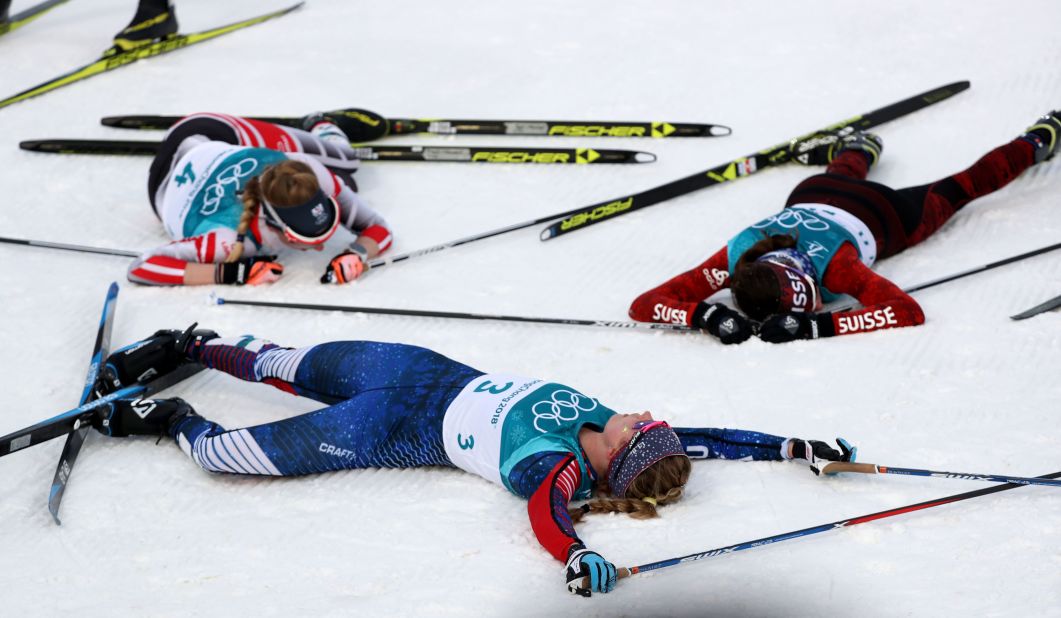 The United States' Jessica Diggins collapses alongside her competitors after competing in cross-country skiing.