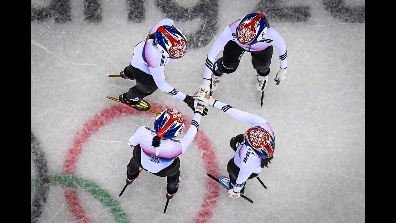 The South Korea women's 3,000-meter relay team holds hands before going on to win its short track speedskating heat.