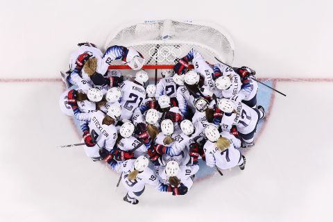 Team United States huddle at the goal before a women's ice hockey game against Finland.