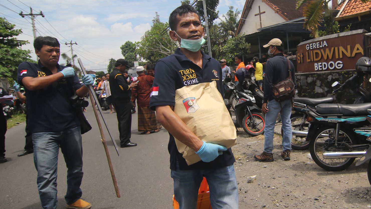 Indonesian police carry evidence after an attack at a church Sunday in Sleman, Yogyakarta province. 