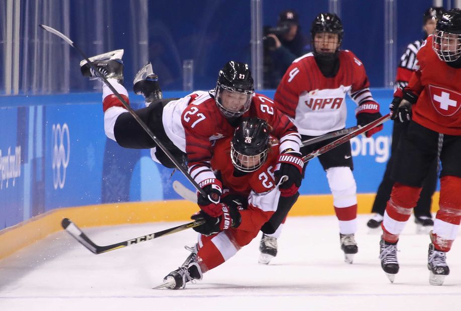 Shoko Ono of Japan falls on top of Dominique Ruegg of Switzerland during a women's hockey game.