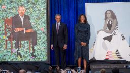 Former US President Barack Obama and First Lady Michelle Obama stand beside their portraits after their unveiling at the Smithsonian's National Portrait Gallery in Washington, DC, February 12, 2018. / AFP PHOTO / SAUL LOEB        (Photo credit should read SAUL LOEB/AFP/Getty Images)