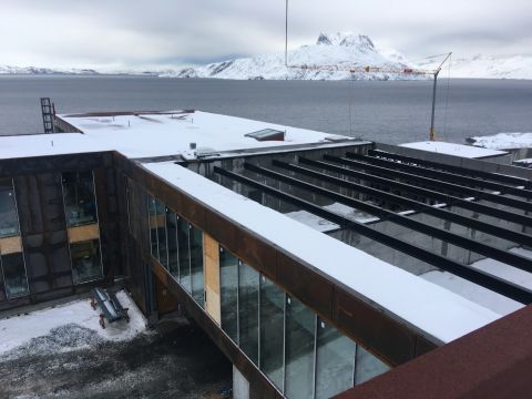 Ny Anstalt under construction. The 130 square foot (12 square meter) cells are positioned to enjoy the best views of Sermitsiaq, a towering mountain on an offshore island.  