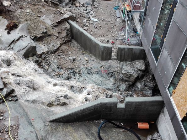 During spring, snowmelt and rocks cascade down the slopes of Lille Malene mountain. The architects enlarged channels under the buildings to control the massive water flows.