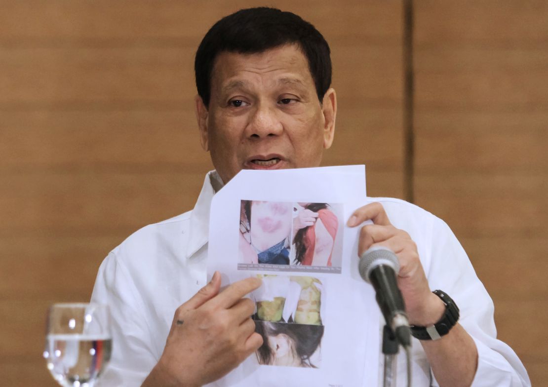 Philippine President Rodrigo Duterte shows a photo of an abused Filipina worker in Kuwait during a press conference in Davao City, February 9, 2018.  