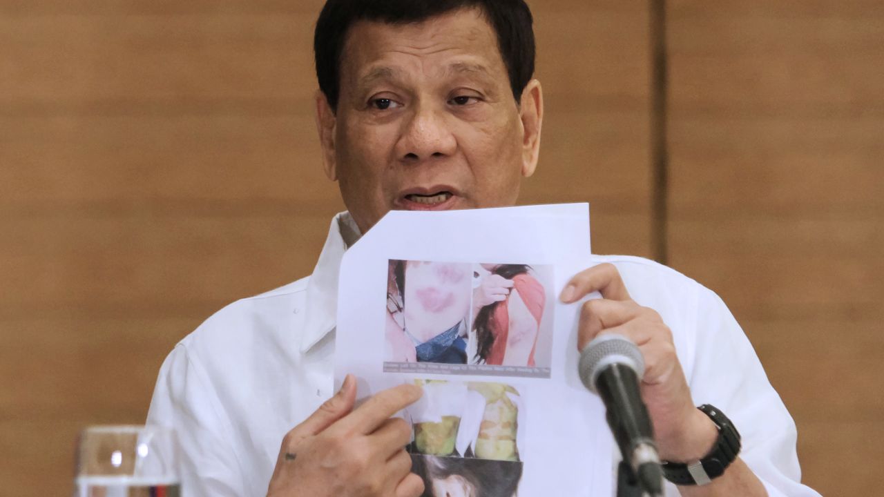 Philippine President Rodrigo Duterte shows a photo of an abused Filipina worker in Kuwait during a press conference in Davao City, February 9, 2018.