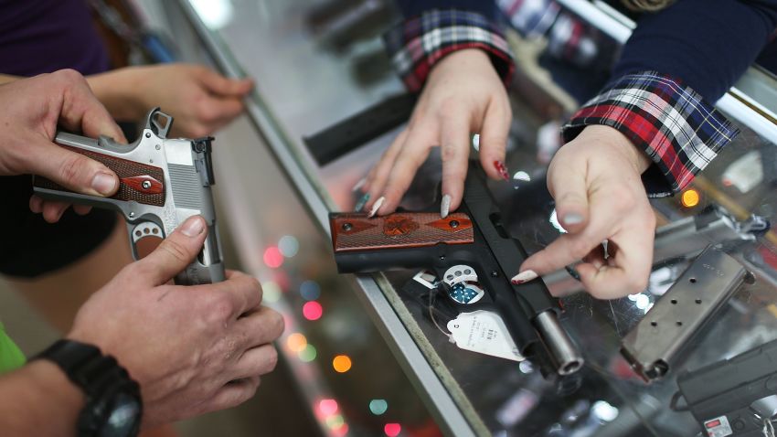 POMPANO BEACH, FL - DECEMBER 23: A customer compares handguns before buying one as a Christmas present at the National Armory gun store on December 23, 2015 in Pompano Beach, Florida. F.B.I. stats indicate that gun sales have increased dramatically this year, as reports indicate that firearms are a popular choice for a holiday present.