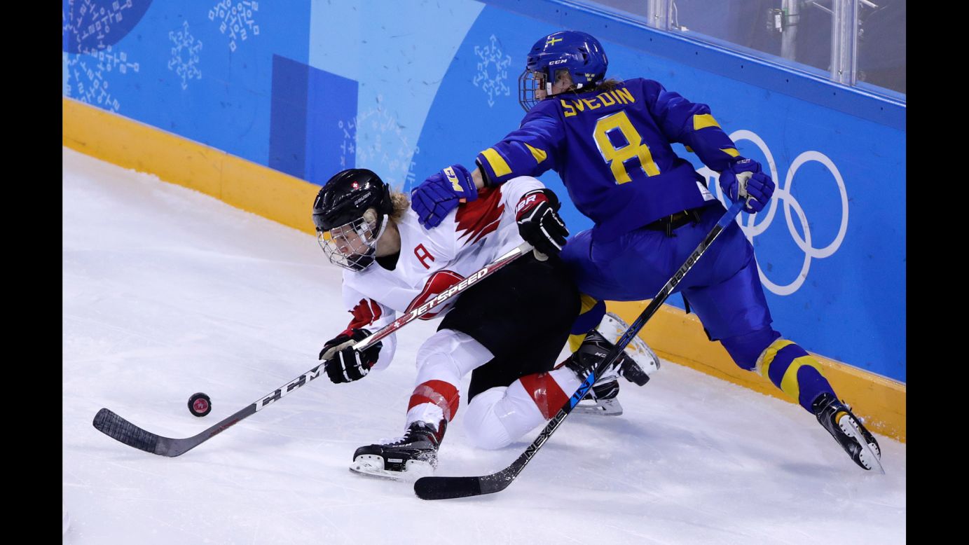 Switzerland's Lara Stalder, left, and Sweden's Annie Svedin battle for the puck during a preliminary-round hockey game. The Swiss won 2-1.