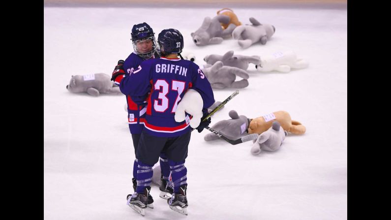 Stuffed animals lie on the ice near Lee Jingyu, left, and Randi Griffin after the Korean women's hockey team was eliminated from medal contention. The team, which includes players from both North and South Korea, lost to Japan 4-1. It had been shut out in its other two games.