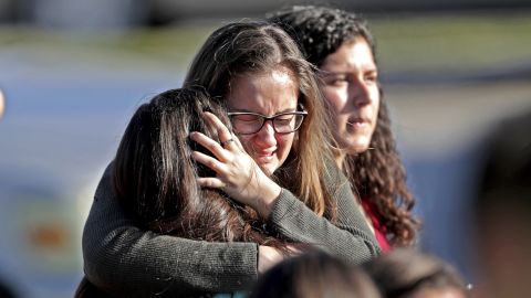 Students released from a lockdown embrace following following a shooting at Marjory Stoneman Douglas High School in Parkland, Fla., Wednesday, Feb. 14, 2018. (John McCall/South Florida Sun-Sentinel via AP)