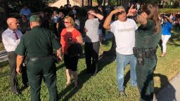 Parents confer with security following a shooting at Marjory Stoneman Douglas High School in Parkland, Florida, a city about 50 miles (80 kilometers) north of Miami, February 14, 2018 .A gunman opened fire at the Florida high school, an incident that officials said caused "numerous fatalities" and left terrified students huddled in their classrooms, texting friends and family for help.The Broward County Sheriff's Office said a suspect was in custody. / AFP PHOTO / Michele Eve SANDBERG        (Photo credit should read MICHELE EVE SANDBERG/AFP/Getty Images)