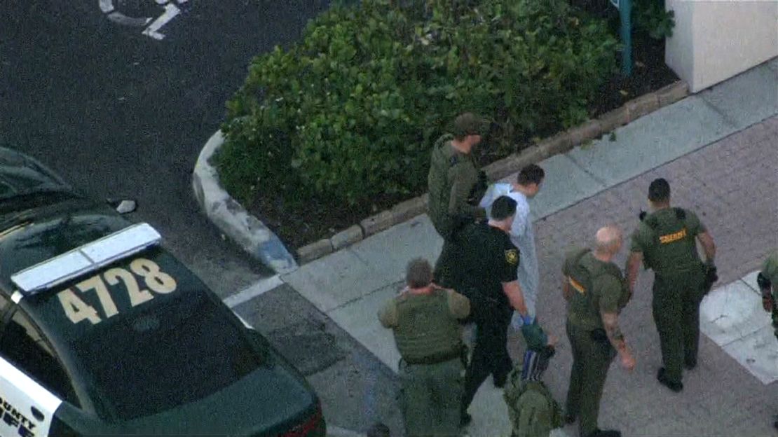 Law enforcement agents transport the suspect in Wednesday's school shooting.