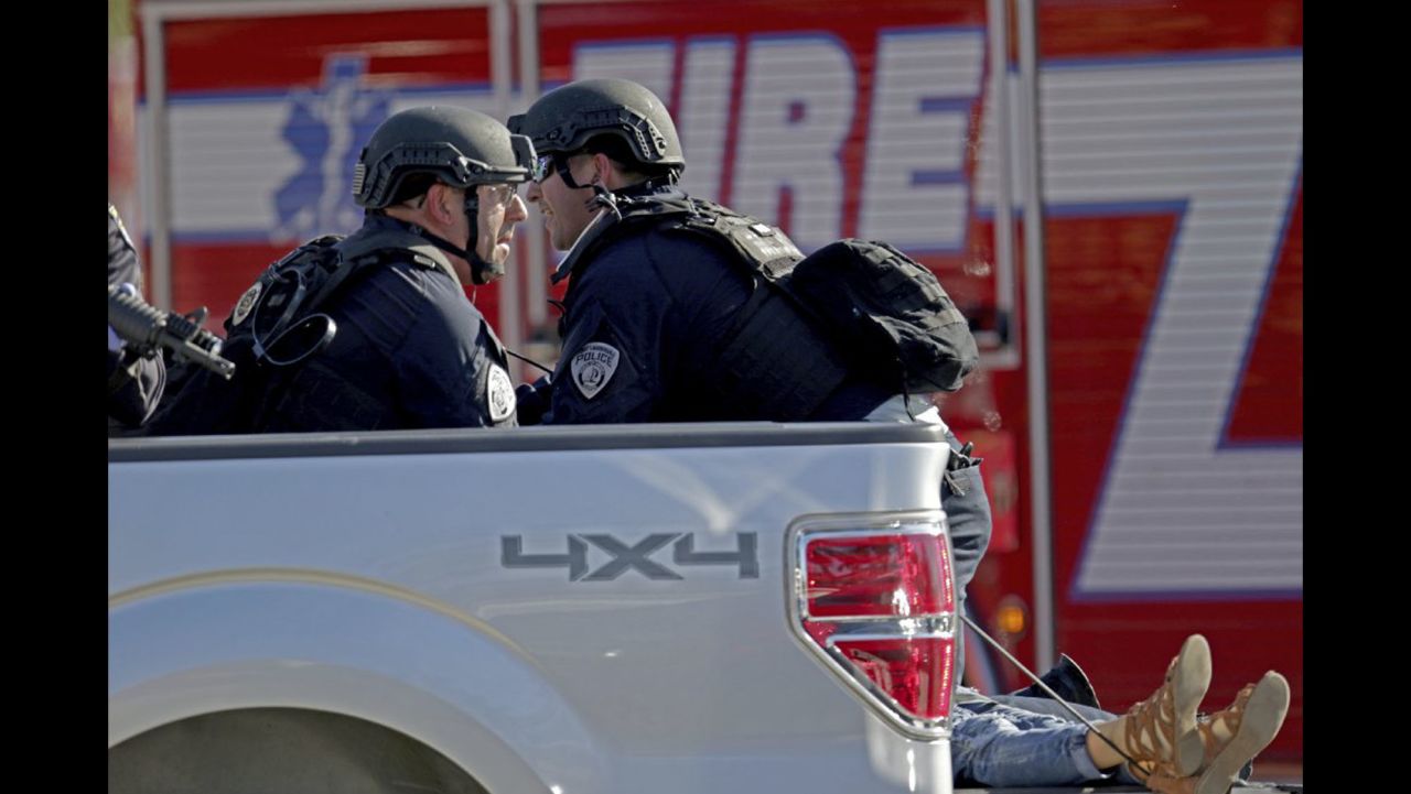 Police officers ride in the back of a pick up truck as they tend to a victim following a shooting at Marjory Stoneman Douglas High School in Parkland, Fla., on Wednesday, Feb. 14, 2018. (John McCall/South Florida Sun-Sentinel via AP)